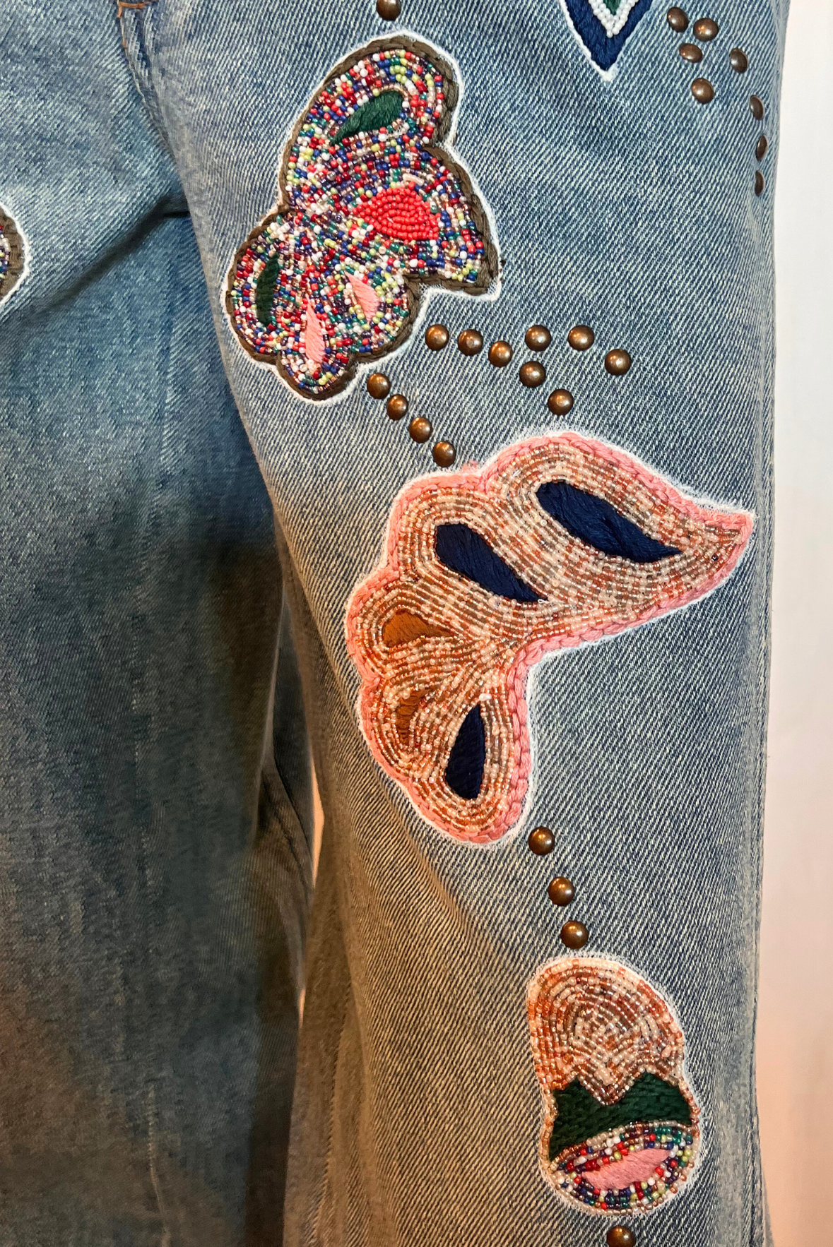 Jeans con maxi ricami e applicazioni