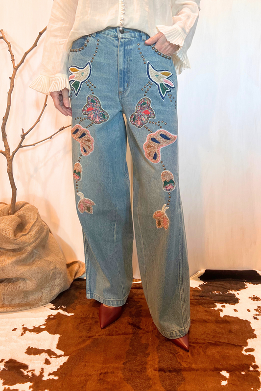Jeans con maxi ricami e applicazioni