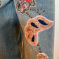 Jeans con maxi ricami e applicazioni
