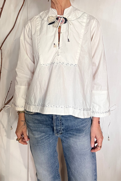 Blusa con ricami e spilla