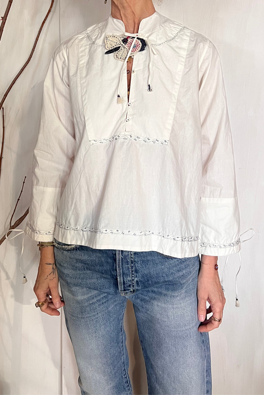 Blusa con ricami e spilla