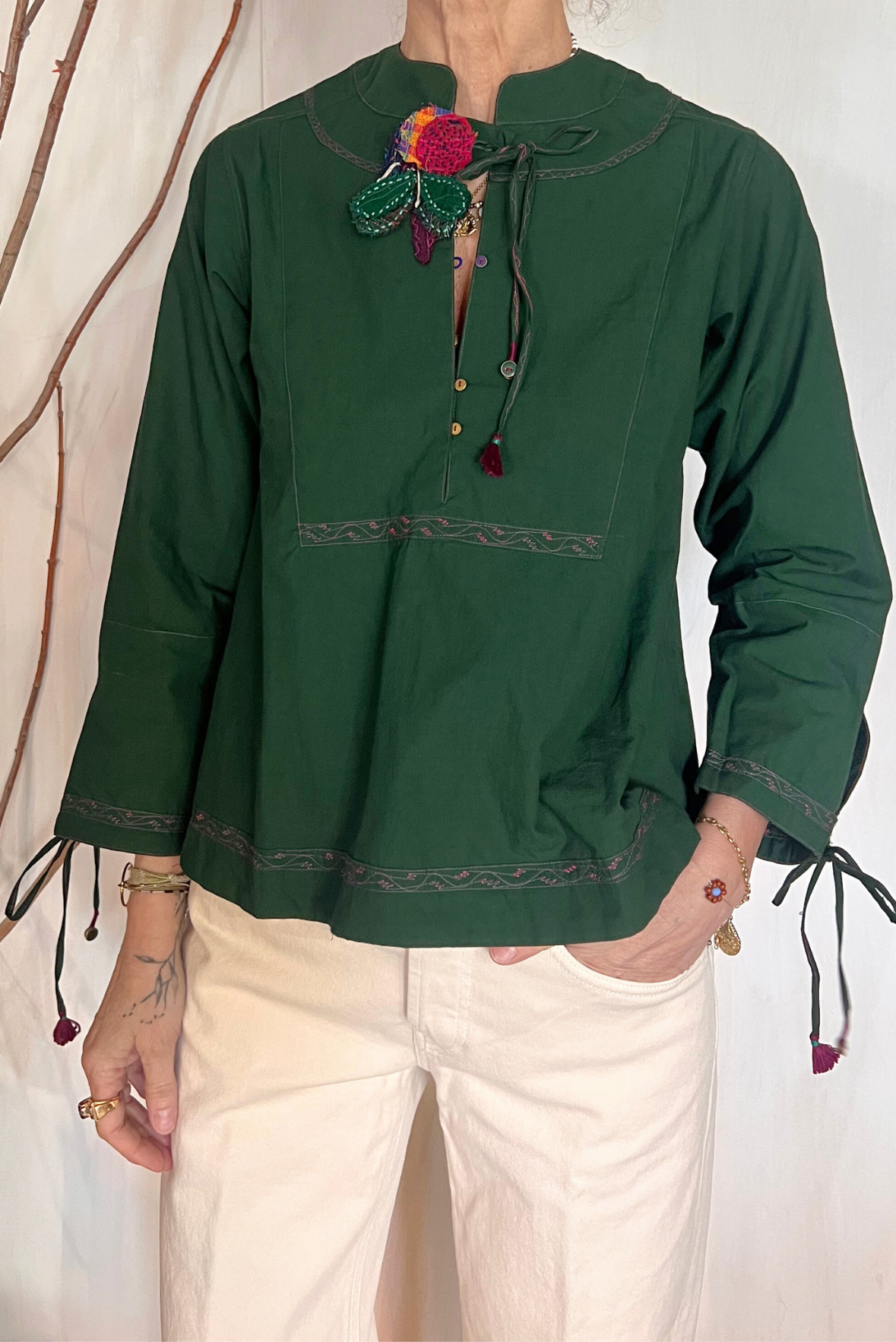 Blusa con ricami e spilla